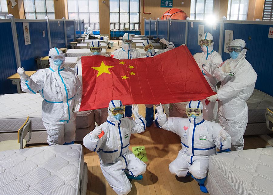 Medical workers pose for photos after seeing cured patients off at the Wuchang temporary hospital in Wuhan, central China's Hubei Province, March 10, 2020. - Xinhua