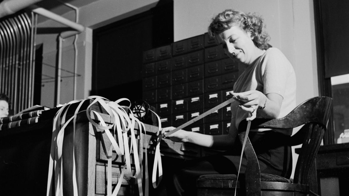 Circa 1950: A so-called back sale being checked on the American Stock Exchange in New York, via ticker tape.